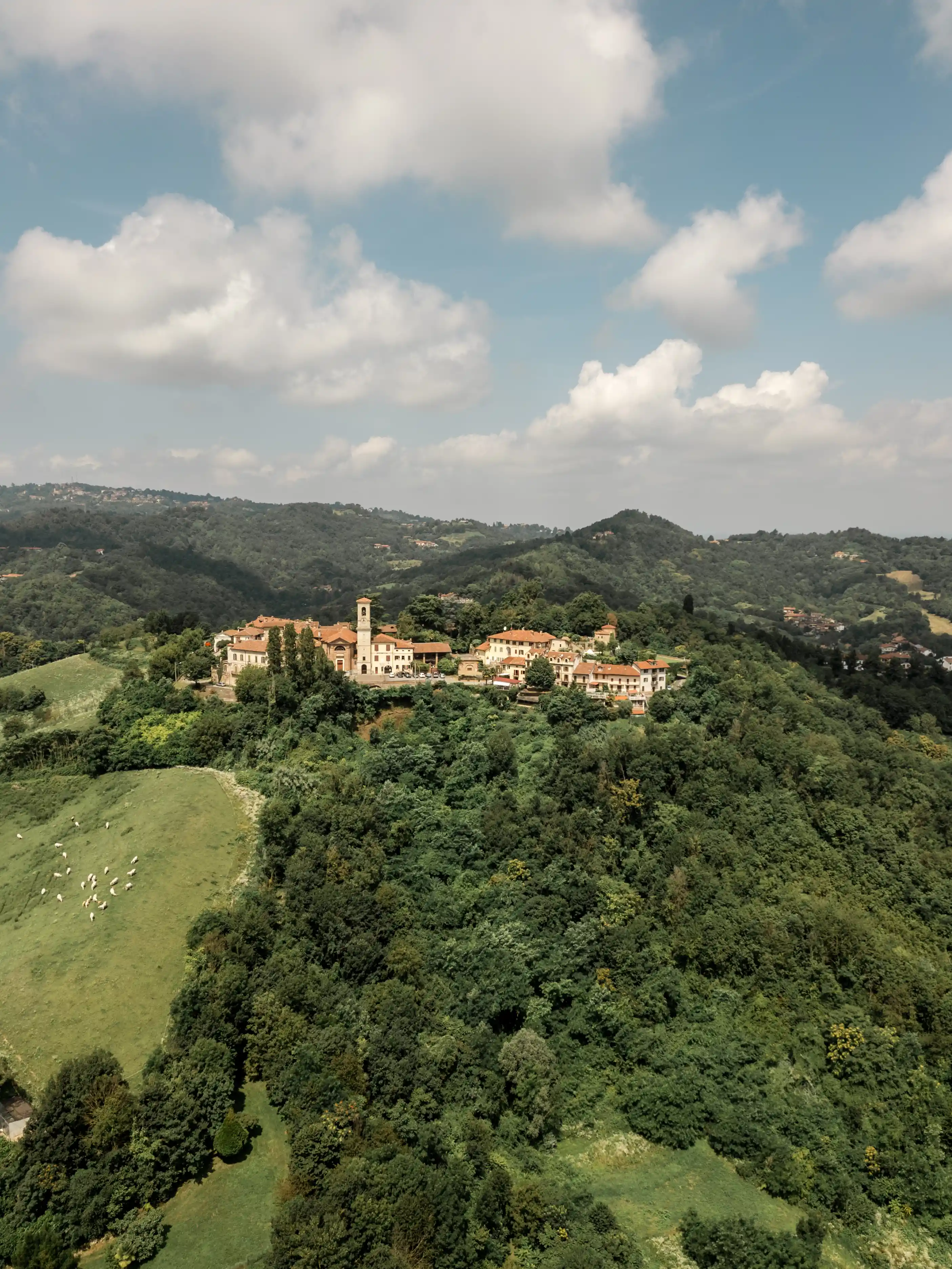 Aerial view of The Workation Village castle and surrounding Piemonte hills